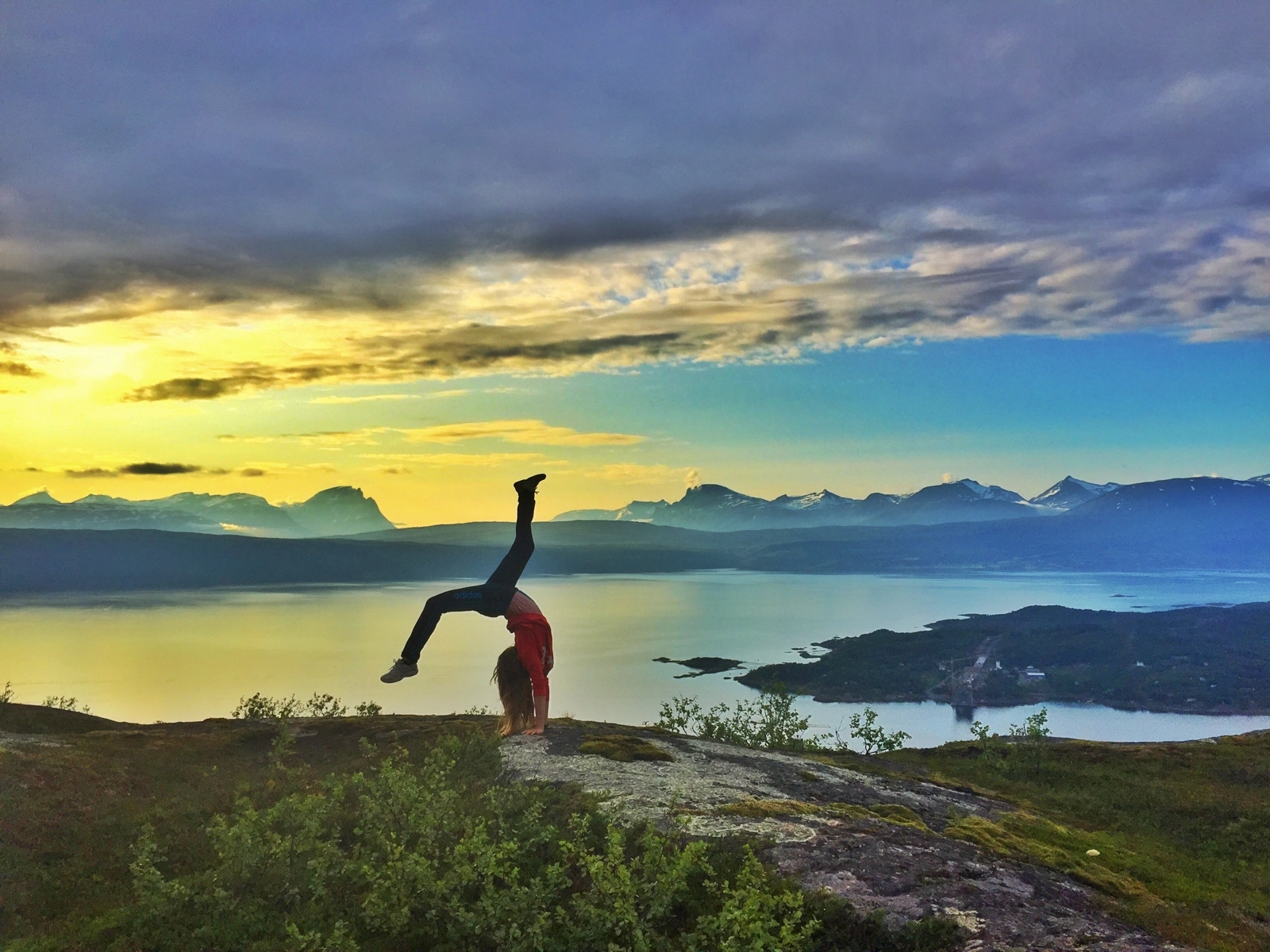 yoga pose with long view of Fjord in background
