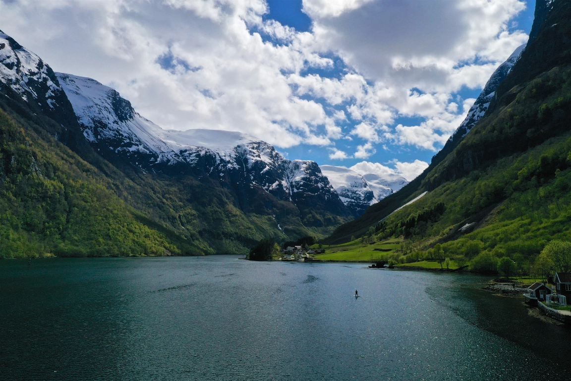 long view of fjord from water level with small village in distance